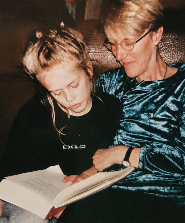 Anne and Dana as a child, reading a book together on the couch