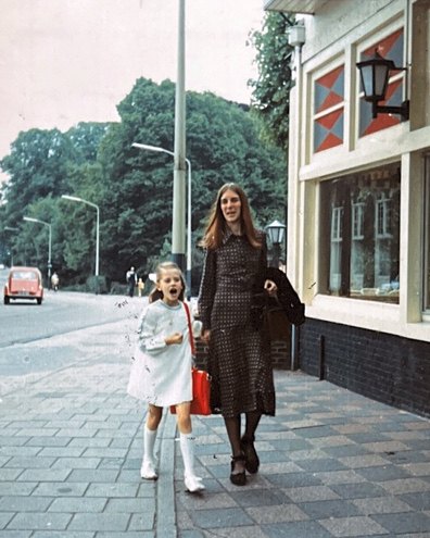 Anne walking on a pavement with Dana's mum as a little girl